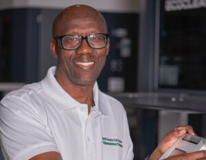 Male worker smiling in a manufacturing plant.