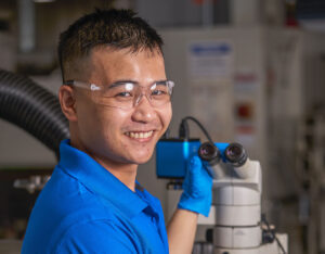Young male worker by a microscope