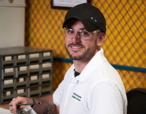 Male worker at desk with tools smiling